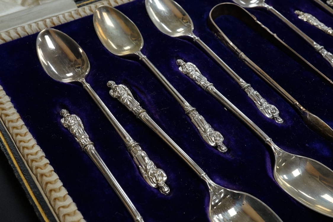 A cased set of twelve Edwardian silver apostle teaspoons with a pair of sugar tongs, Cooper Brothers & Sons, Sheffield, together with a cased Victorian silver bread knife and a cased set of six silver handled steel tea k